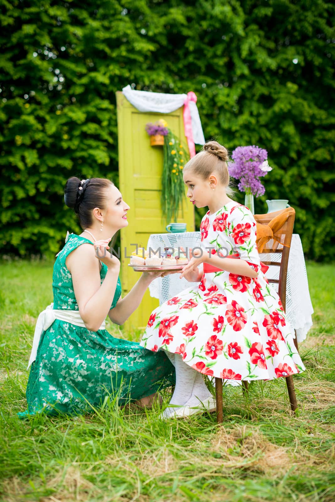 mother with daughter have a breakfast in the garden