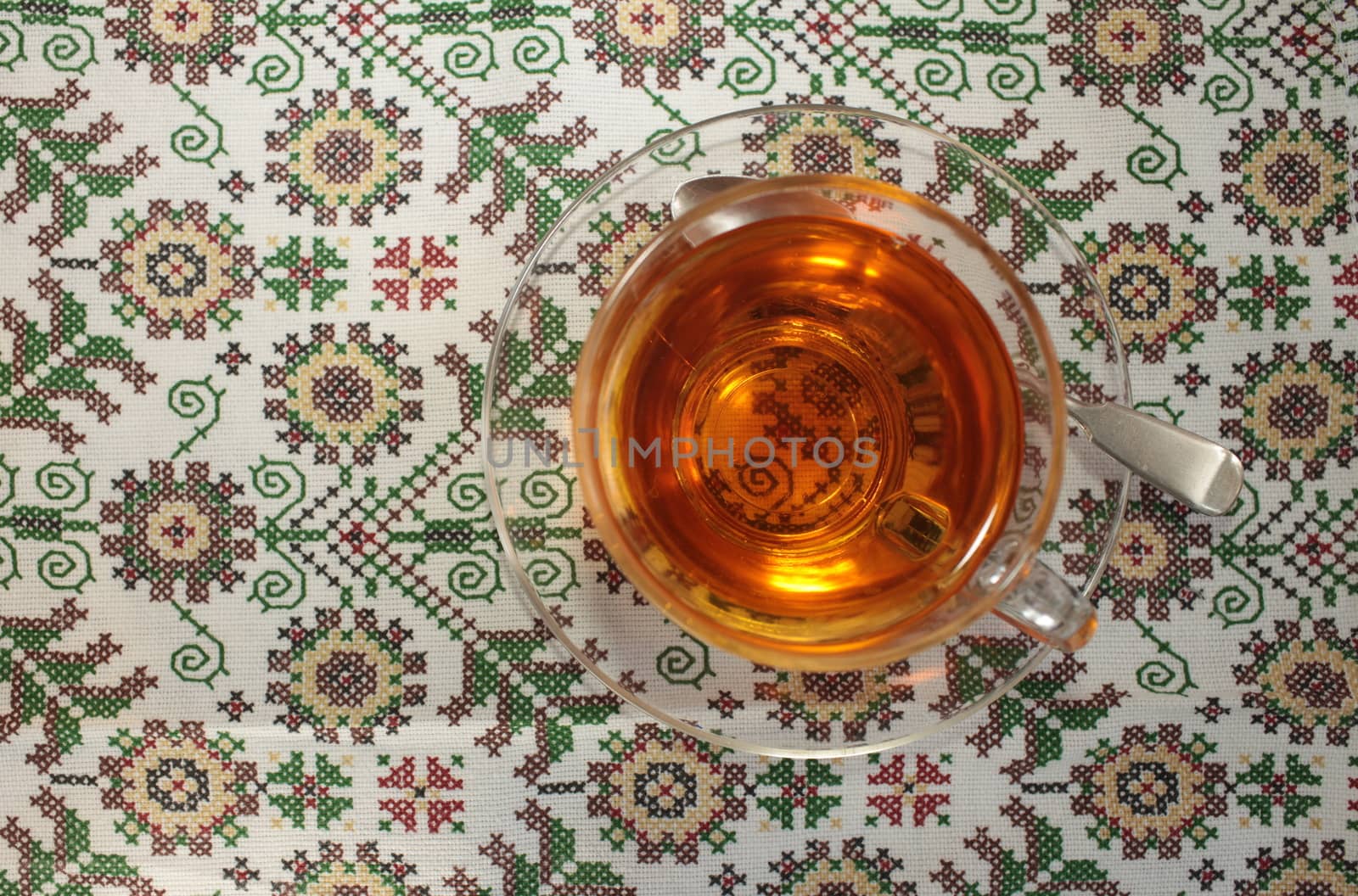 glass cup with tea on a beautiful tablecloth top view