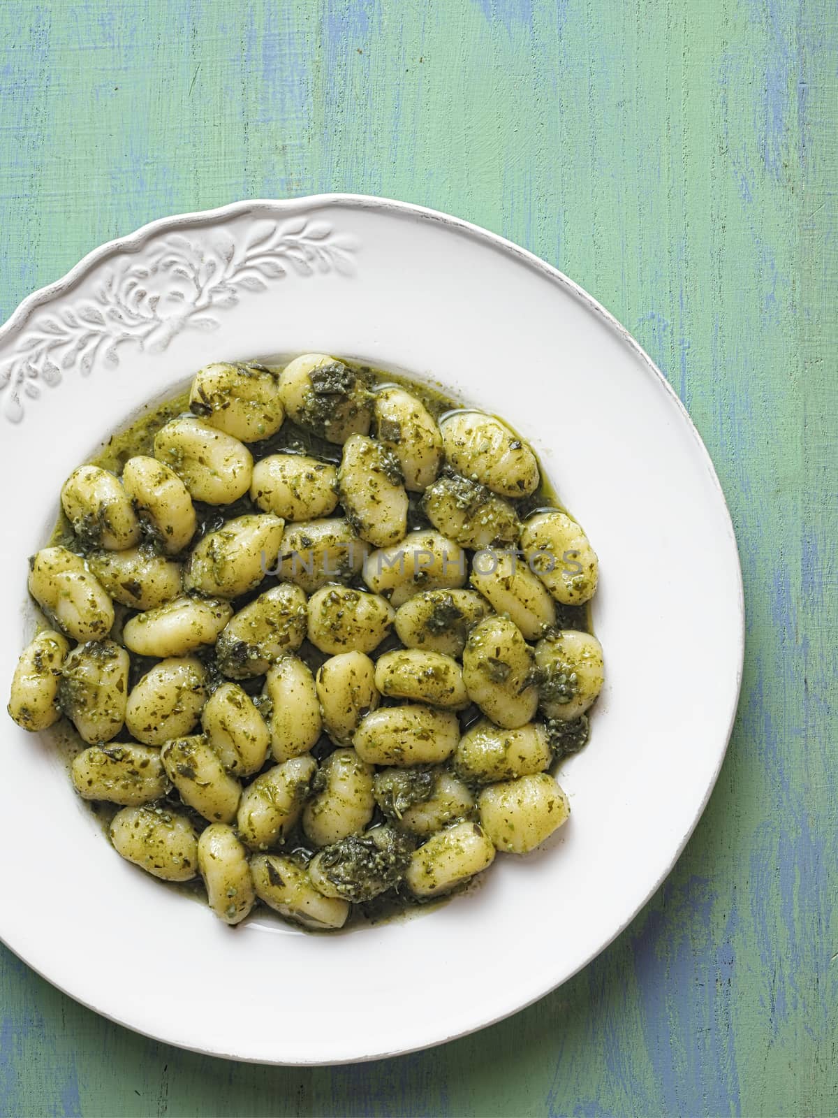 close up of rustic italian gnocchi in pesto sauce