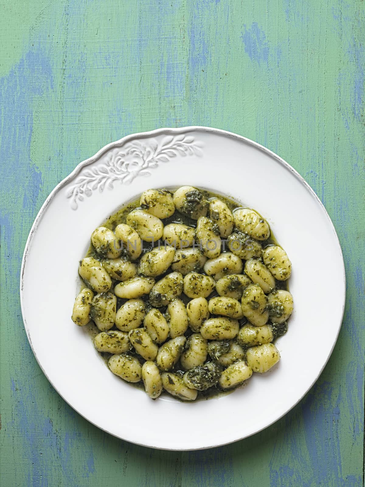 close up of rustic italian gnocchi in pesto sauce