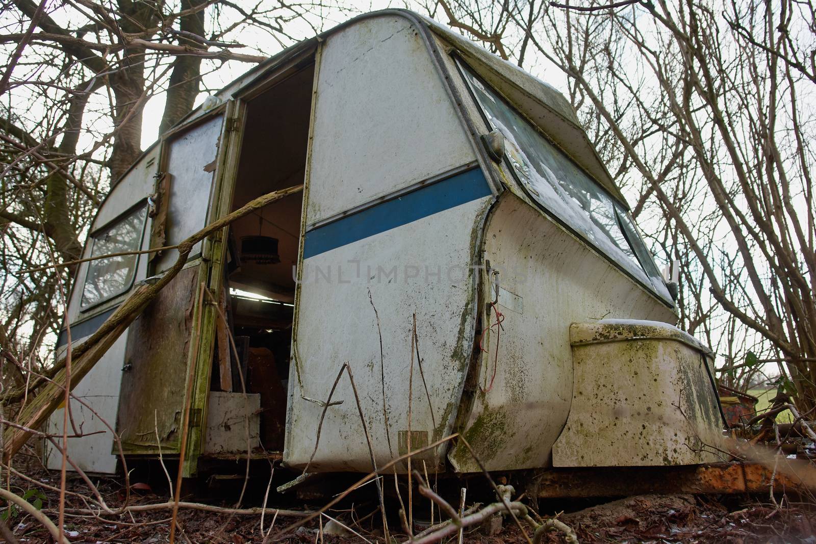Old Vintage Dirty Abandoned Camper Camping Wagon Caravan  in a small forest
