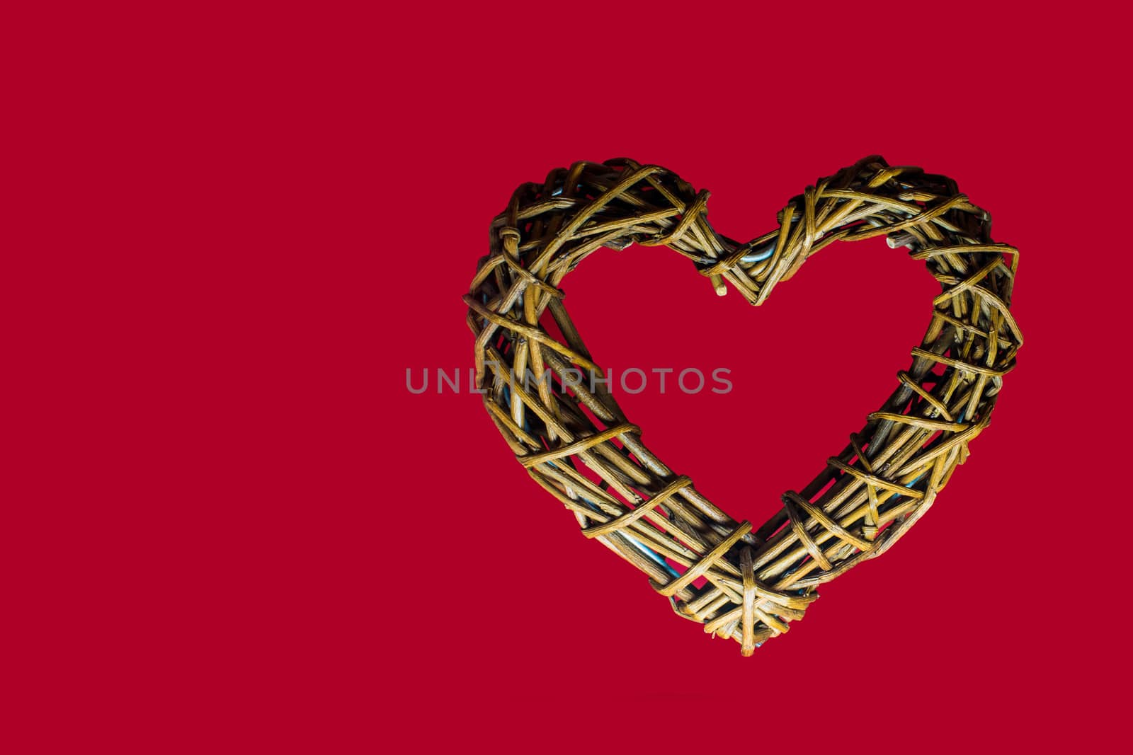 Wooden heart in a red background, symbol of love