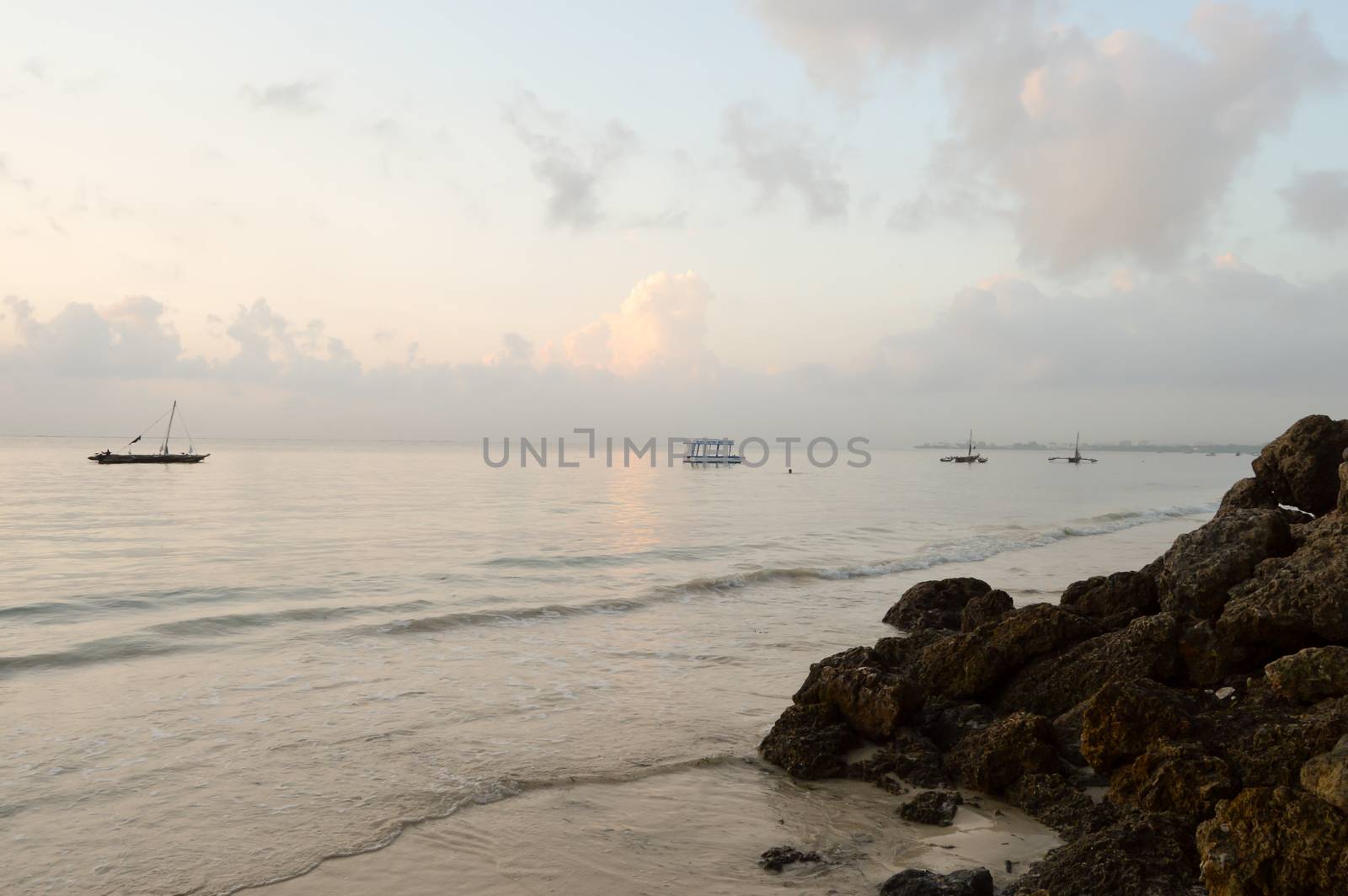 Several dhow on the ocean at sunrise on Bamburi beach in Kenya