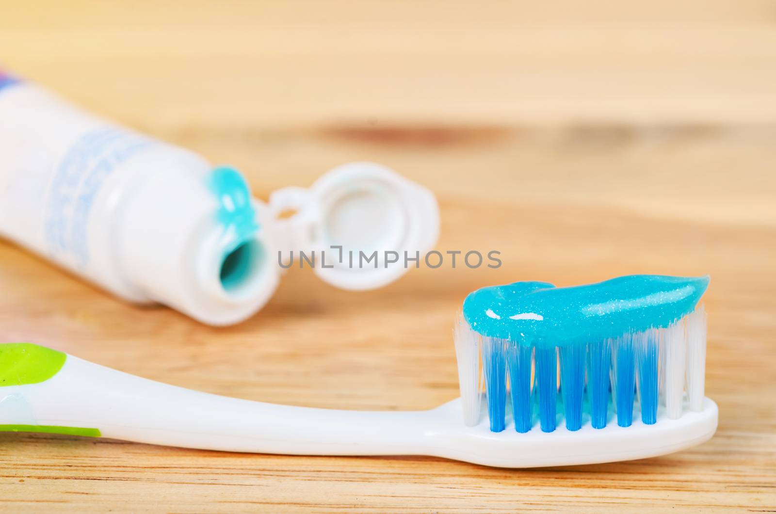 Toothbrush and Toothpaste on a wooden background