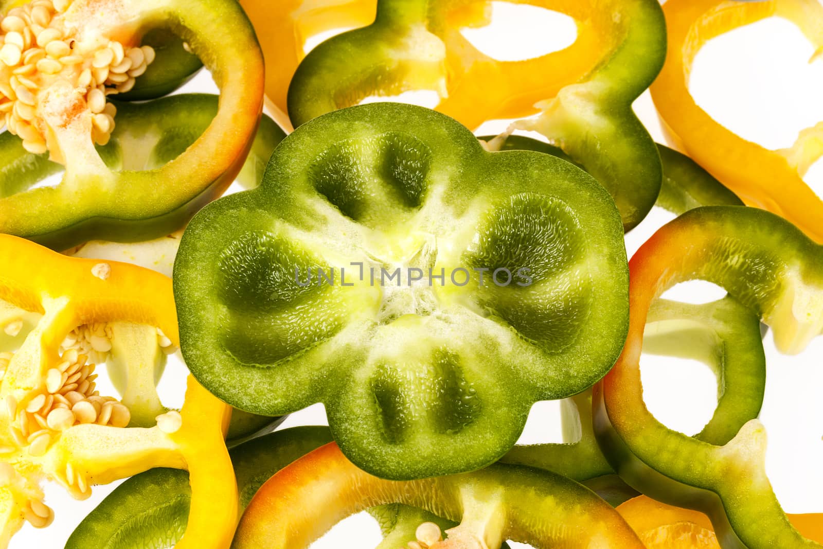 slices of yellow and green pepper vegatebles on white background by mychadre77
