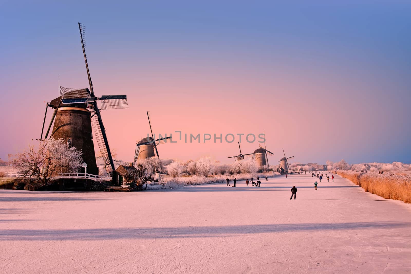 Ice skating at Kinderdijk in the Netherlands at sunset