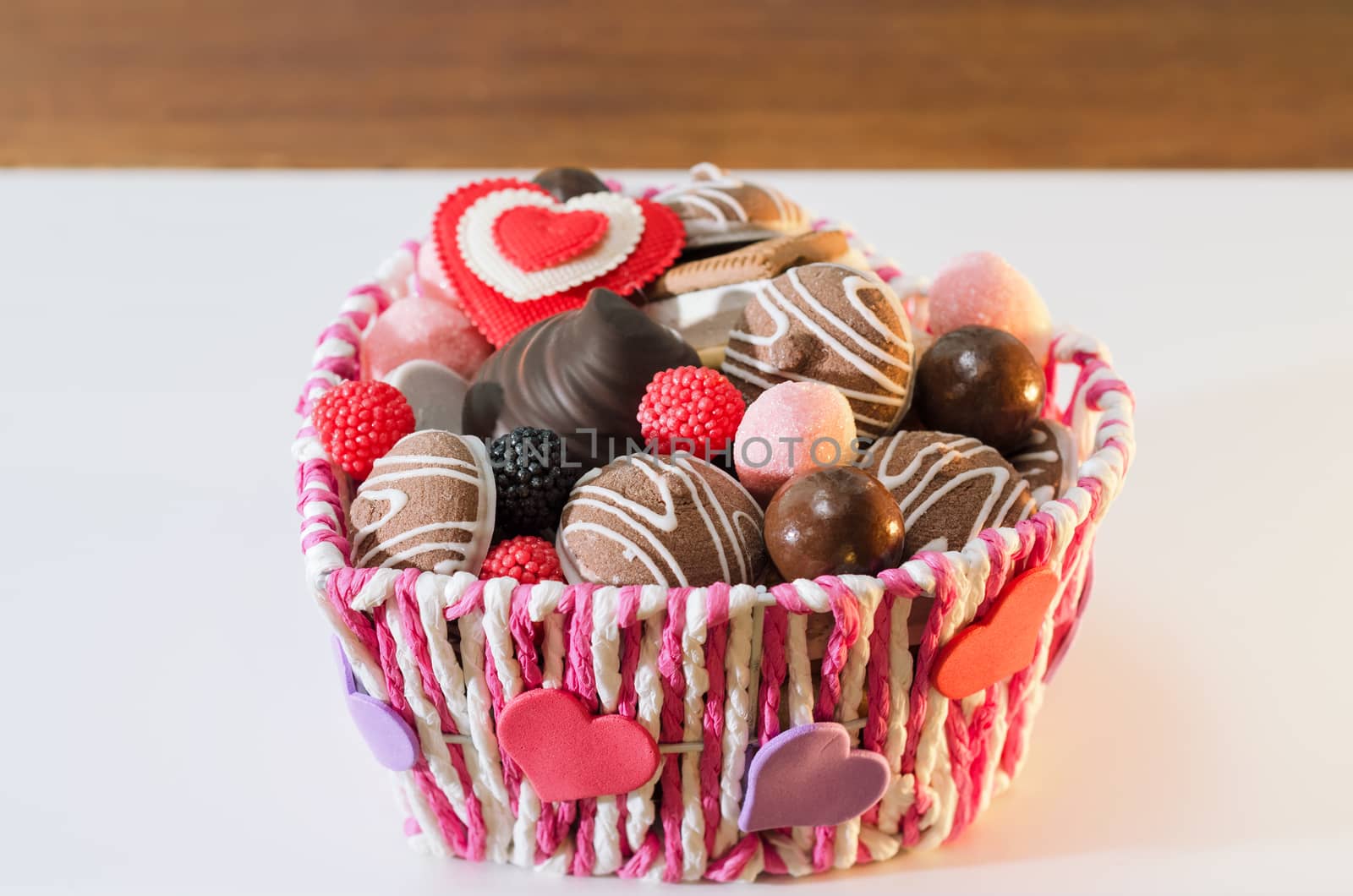 Sweets, biscuits and decorative hearts for Valentine's day in the basket. Selective focus, space for text. by Gaina