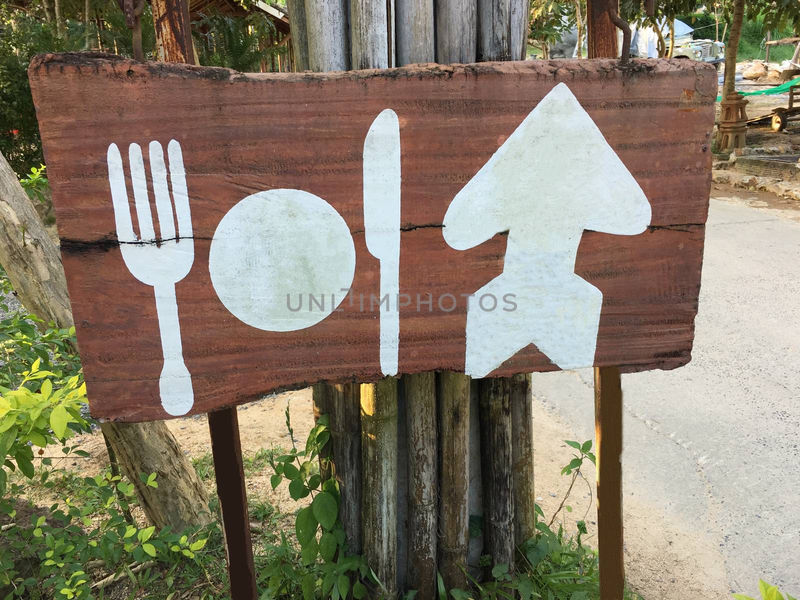 Blank wooden rustic style sign of white plate, folk and knife. wood signboard from cafe restaurant.