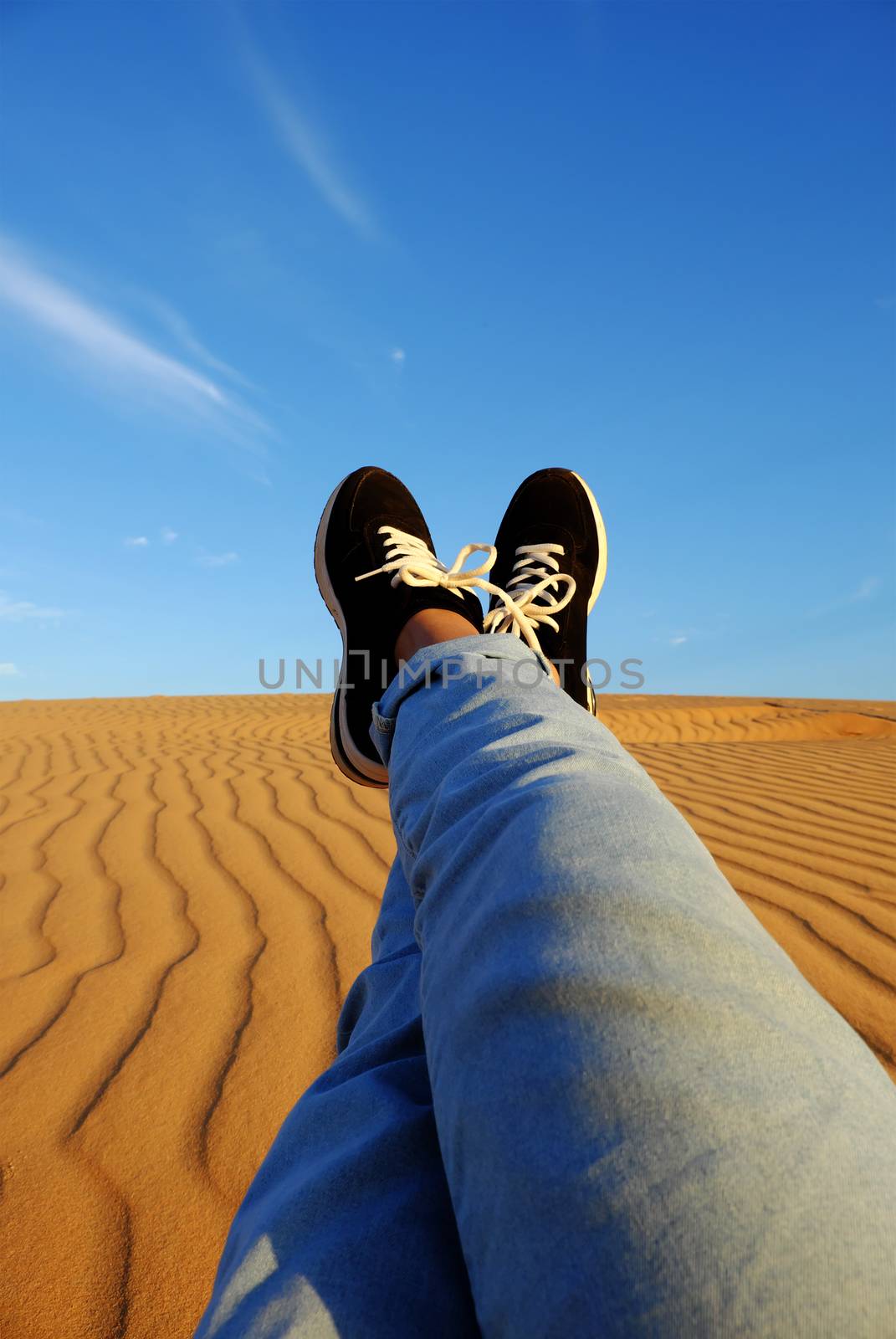 Summertime background with woman foot on sand hill, people relax on orange sandy under blue sky at Mui Ne, Phan Thiet, Vietnam, summer is coming and a trip to adventure make awesome life 