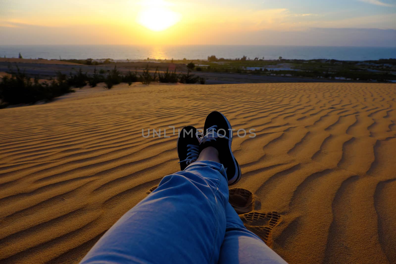 Summertime background with woman foot on sand hill, people relax on orange sandy under blue sky at Mui Ne, Phan Thiet, Vietnam, summer is coming and a trip to adventure make awesome life 