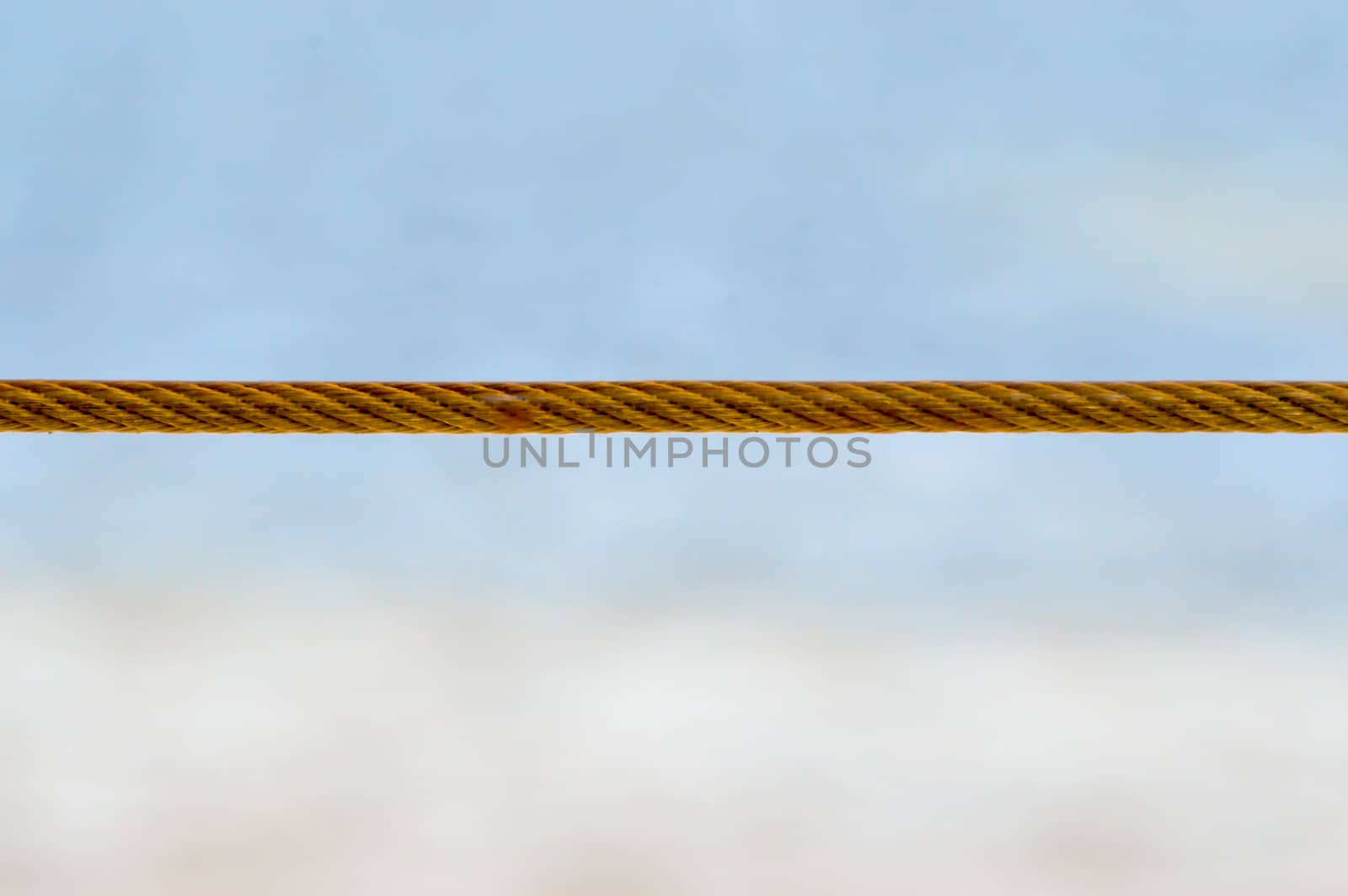 Yellow steel cable with the ocean in background on the beach of Bamburi in Kenya