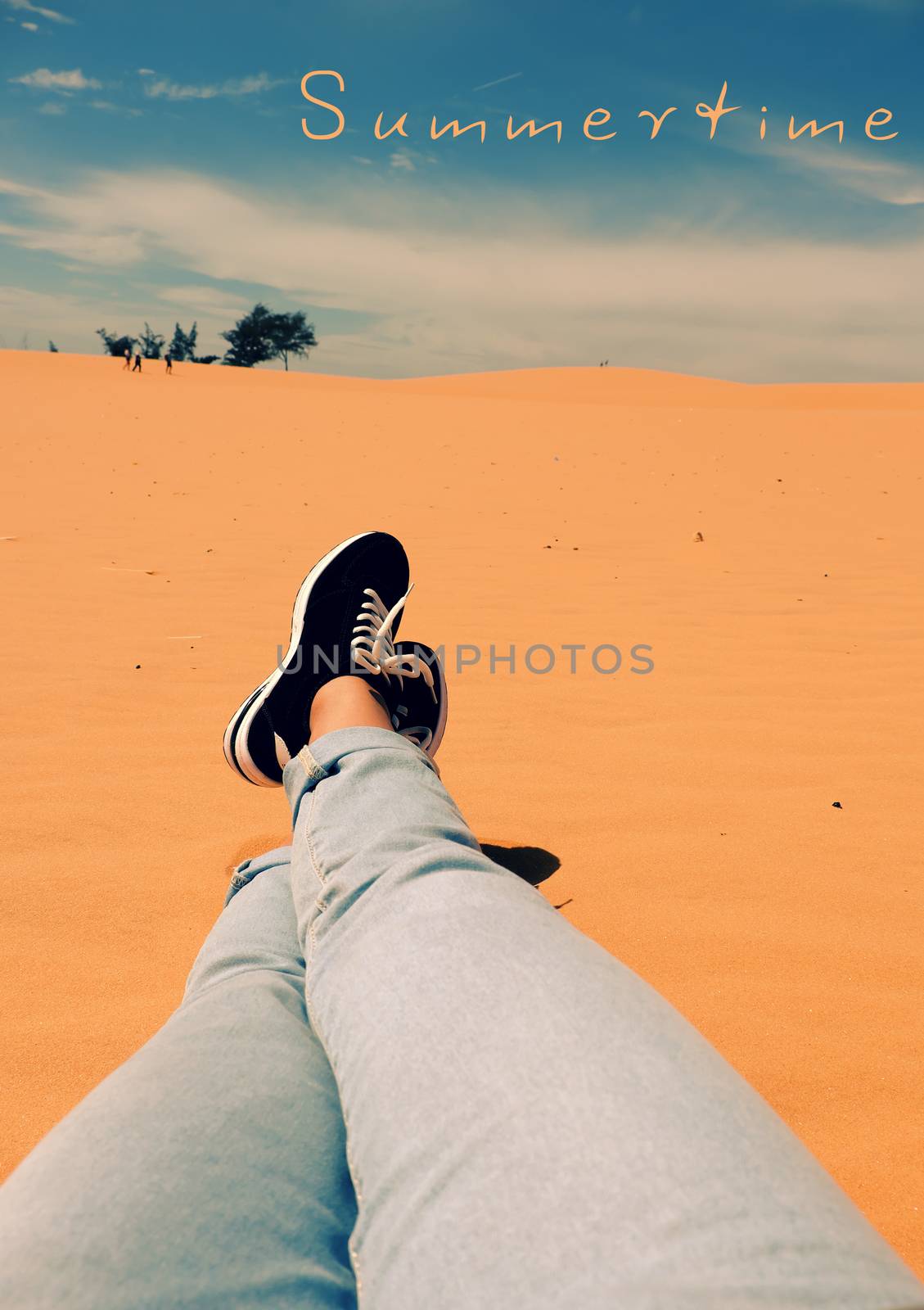 Summertime background with woman foot on sand hill, people relax on orange sandy under blue sky at Mui Ne, Phan Thiet, Vietnam, summer is coming and a trip to adventure make awesome life 