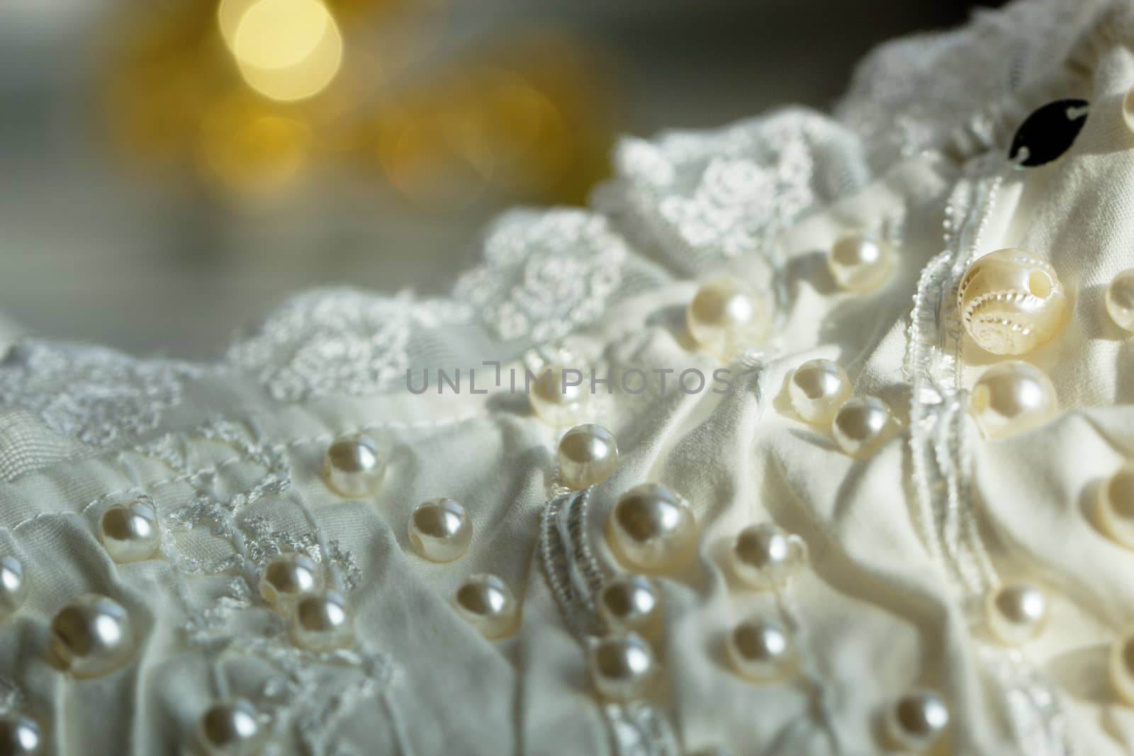 textile wedding background with beads. Tiny pearls embroidered over a wedding dress
