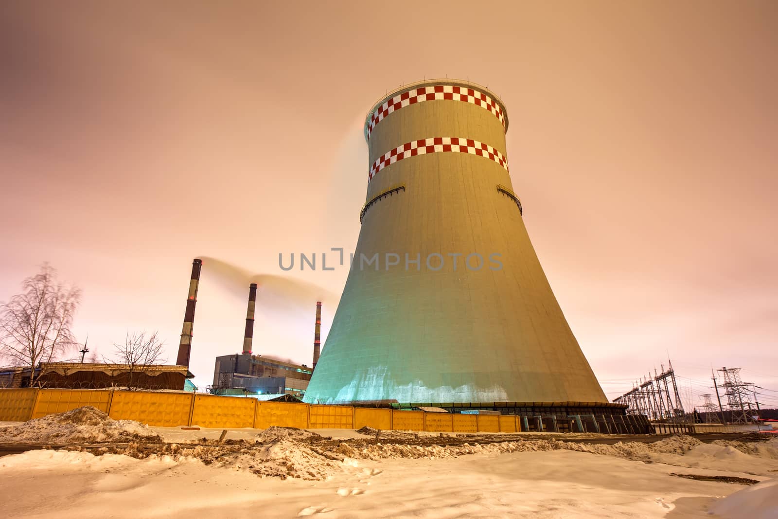 Thermal power plant and cooling towers at night near the city