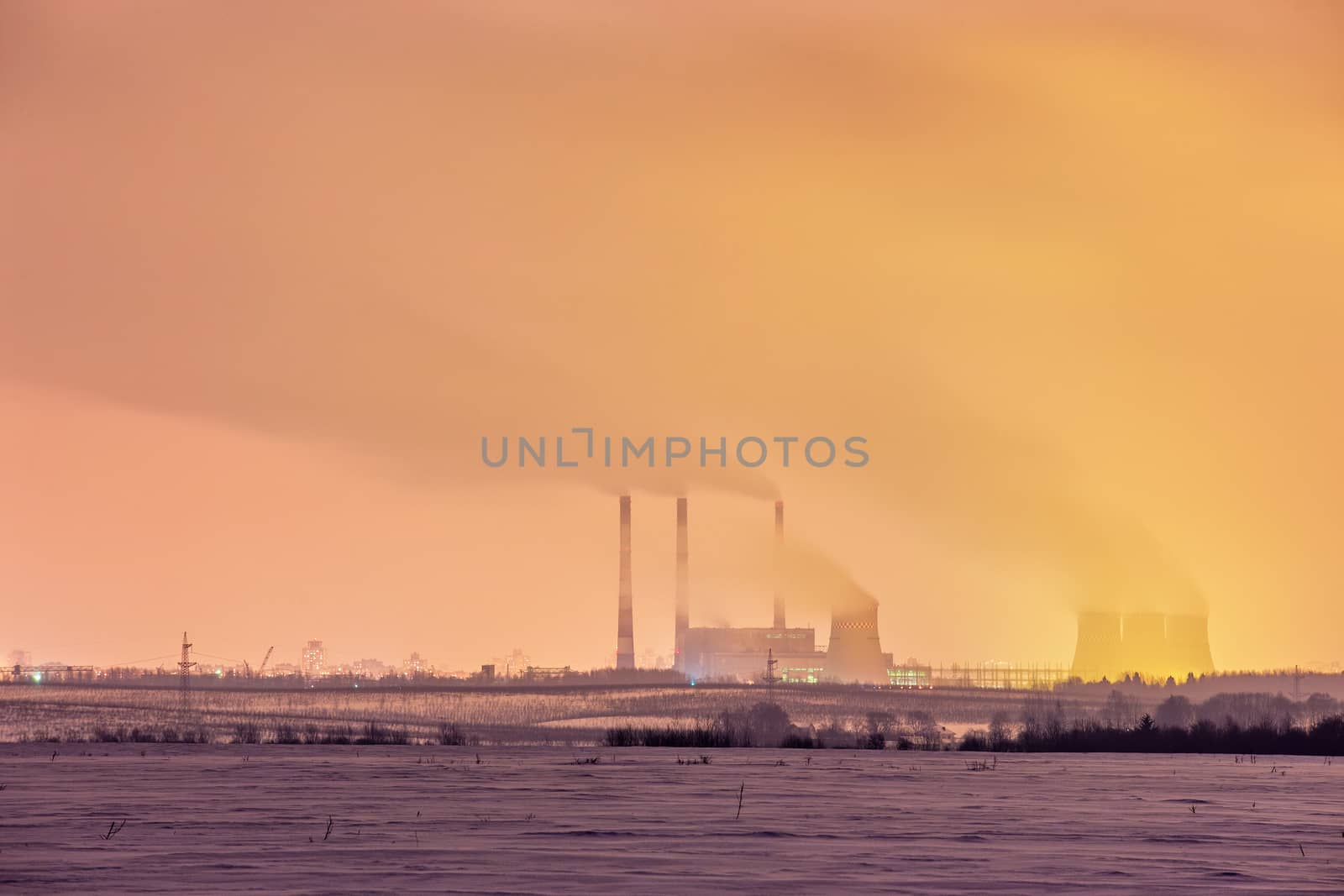 Power plant and cooling towers at dusk near the city