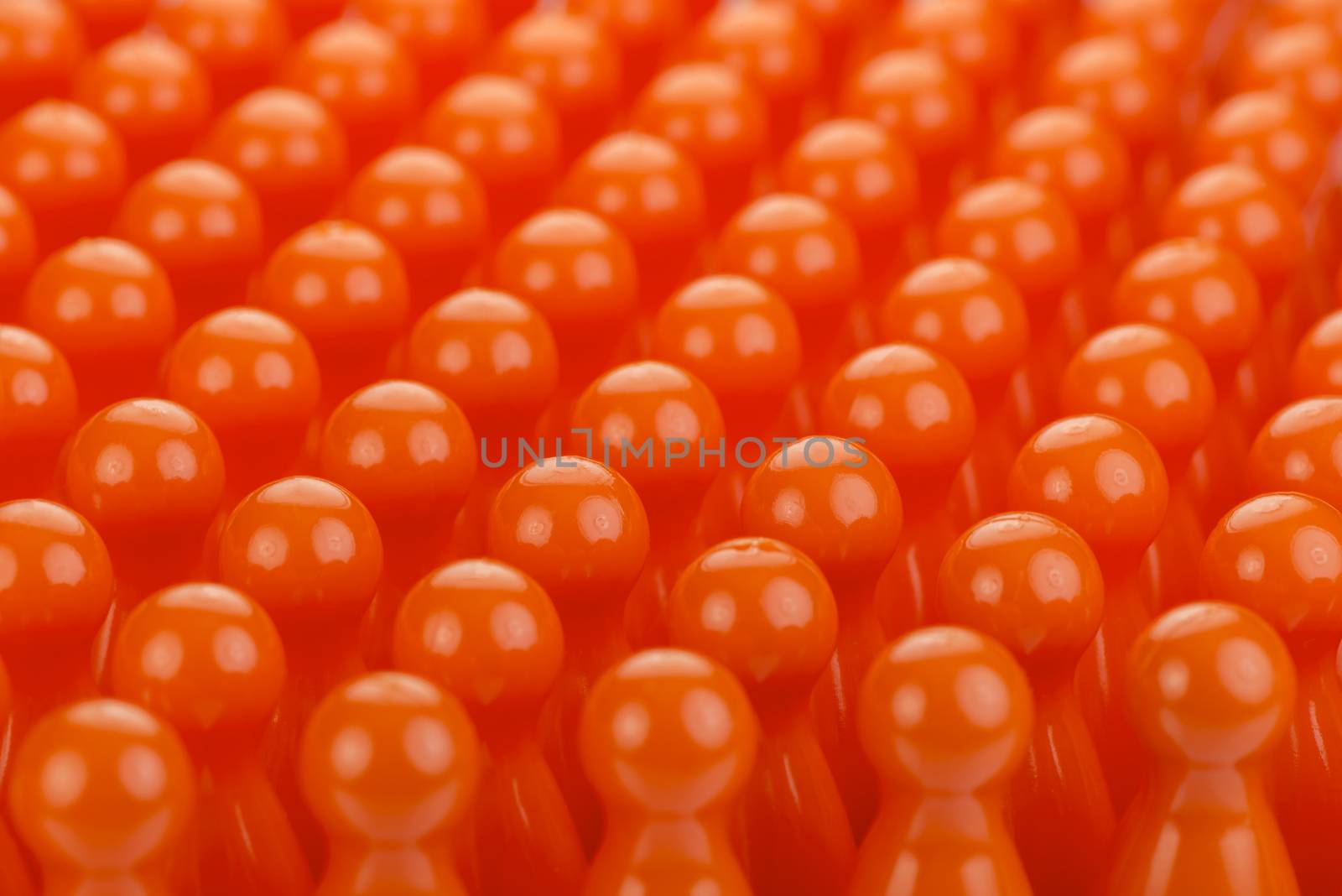 Conceptual orange game pawns as abstract view of a crowd
