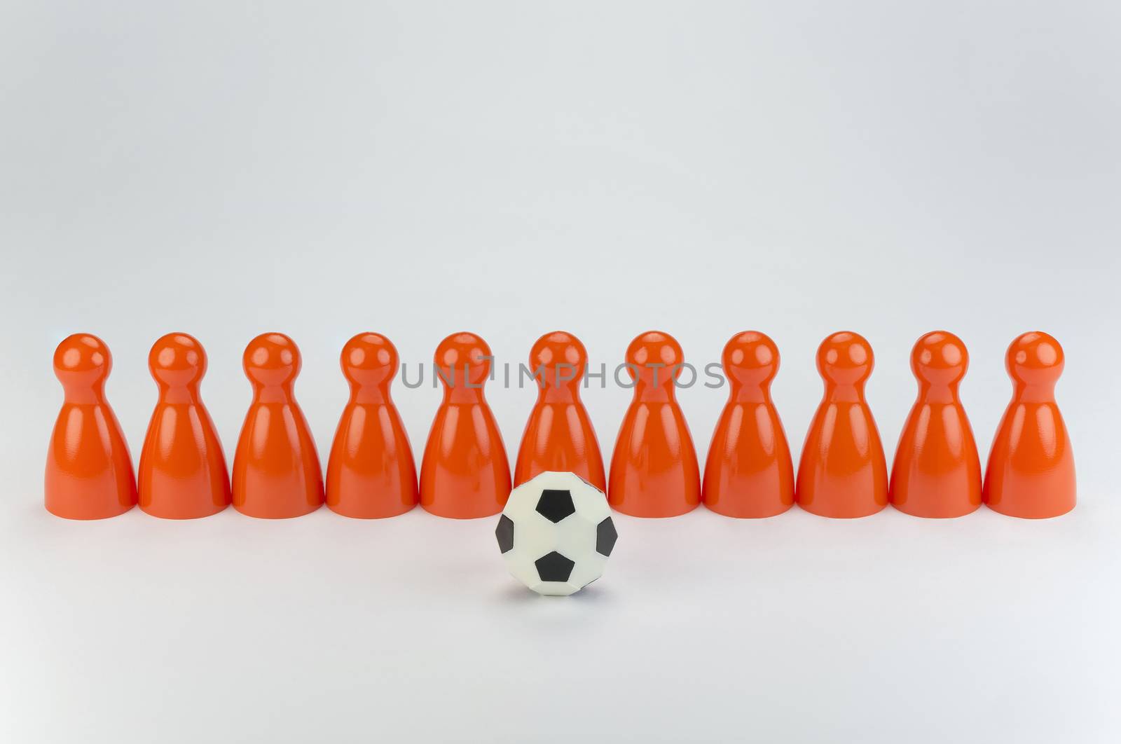 Conceptual orange game pawns as abstract view of a national football team
