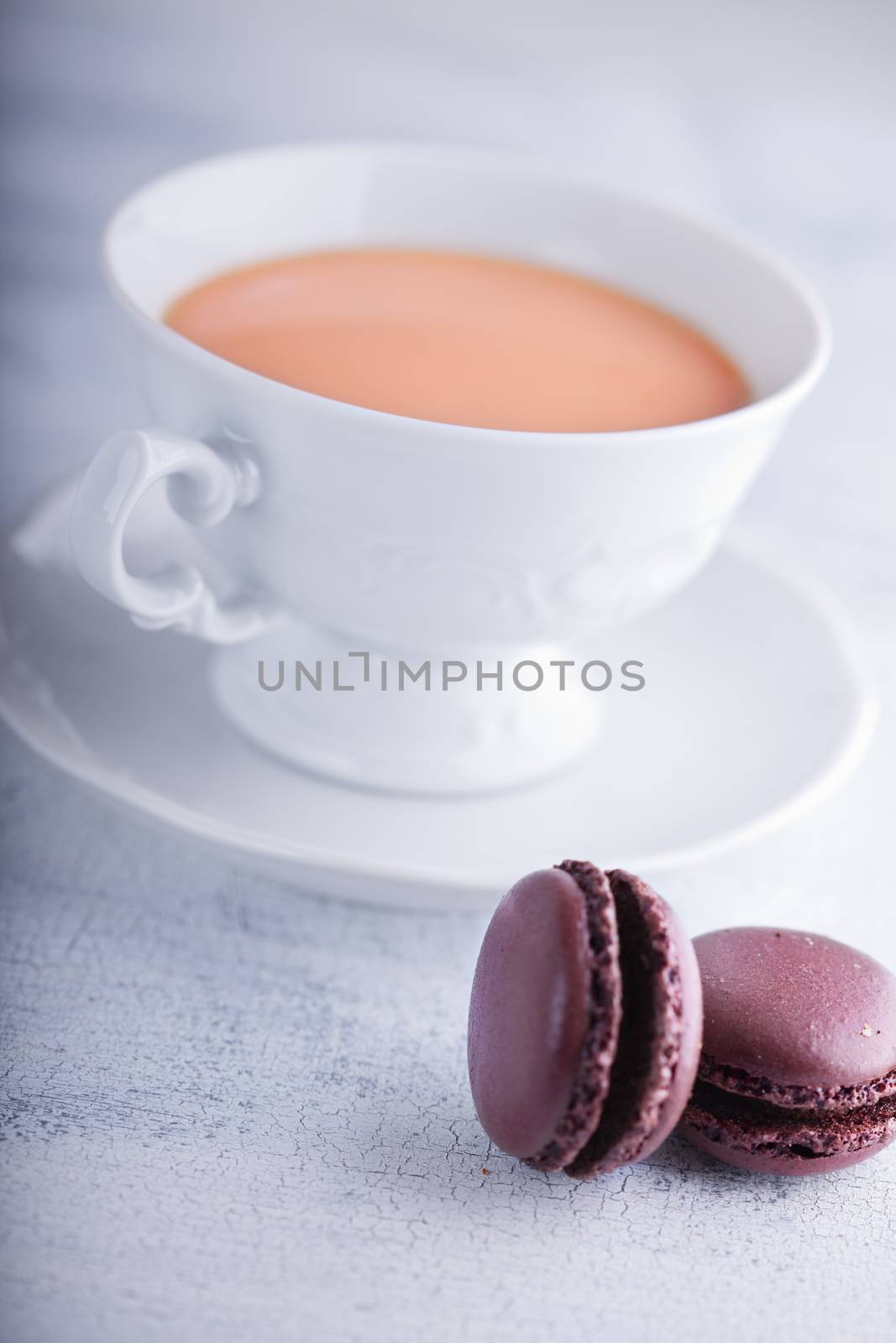 Cup of tea with milk  and chocolate macaroons 