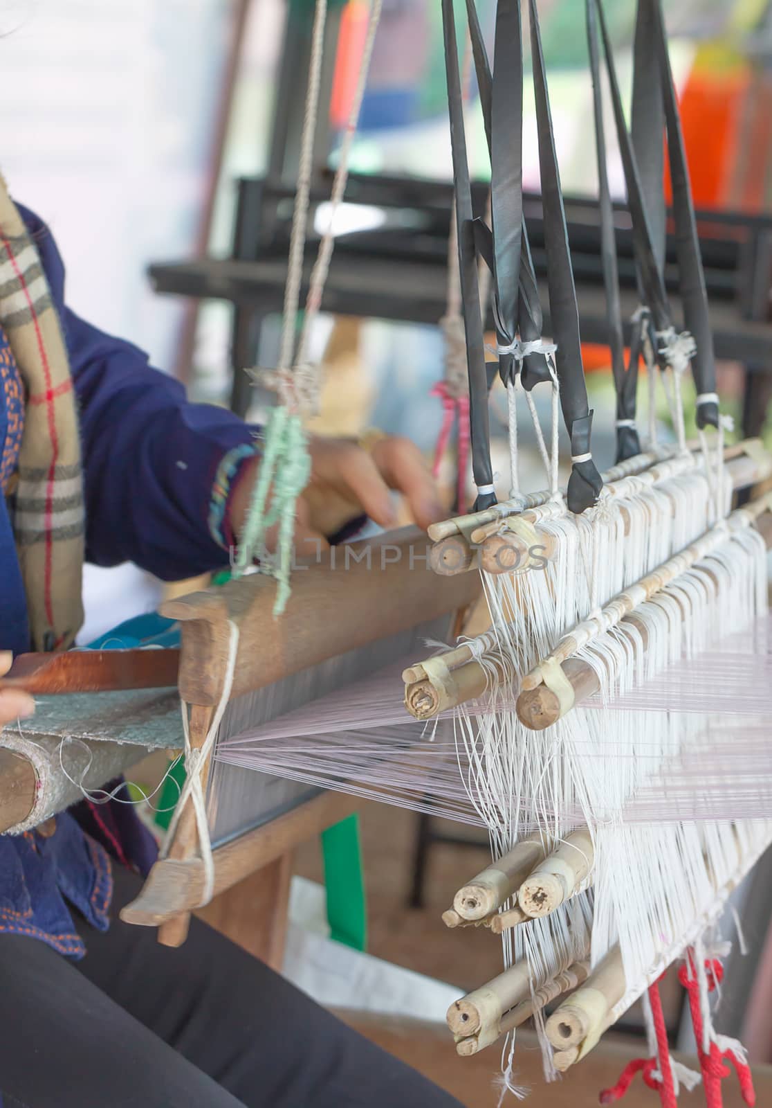 Woman weaving white pattern on loom by stoonn