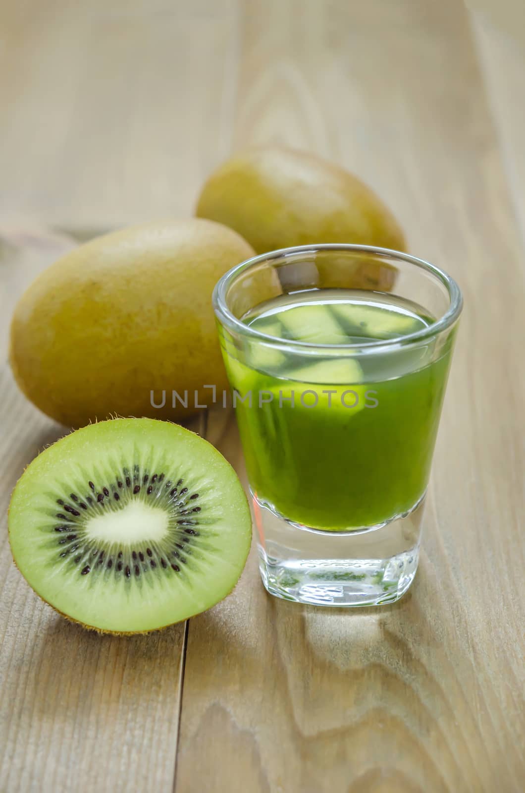 glass of kiwi juice with fresh fruits on wooden table