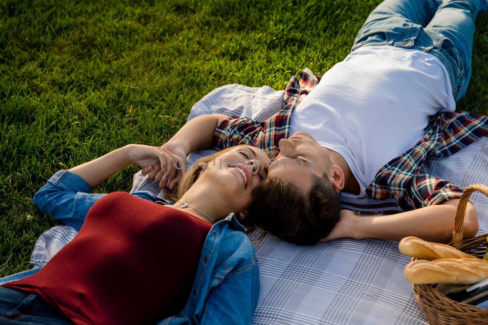 Happy young couple in the park relaxing after the picnic