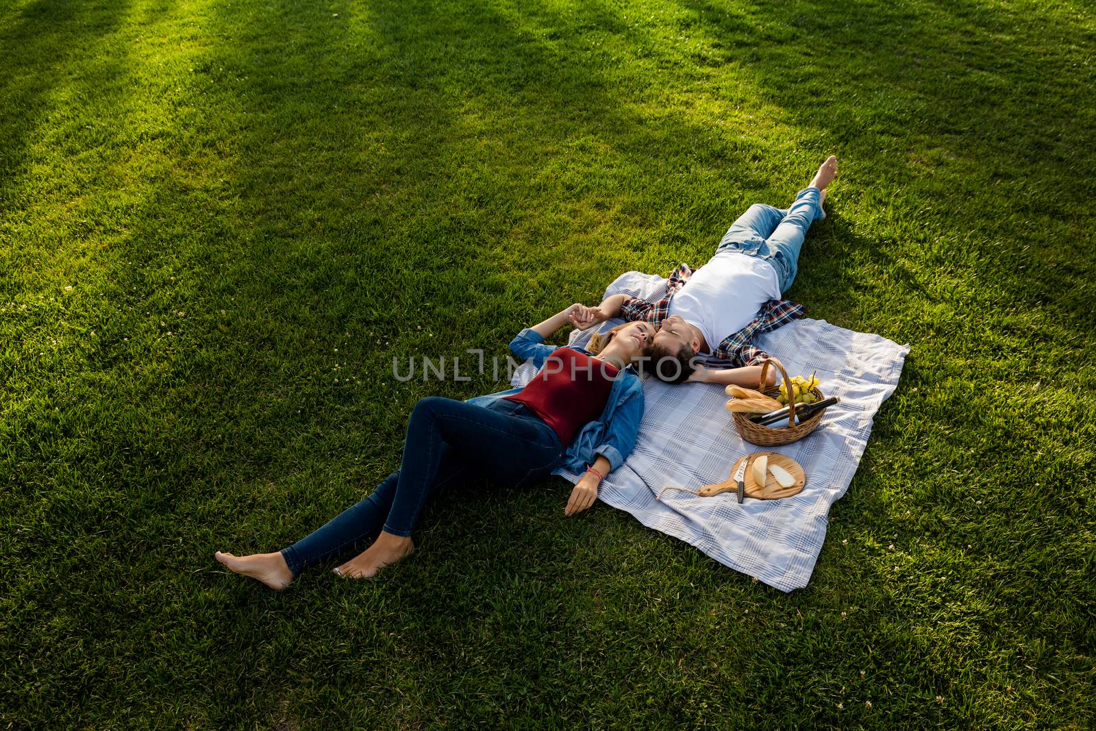 Happy young couple in the park relaxing after the picnic