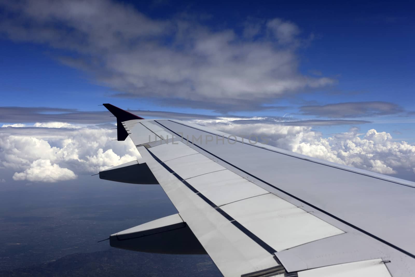 Wing of the plane on a background of clouds