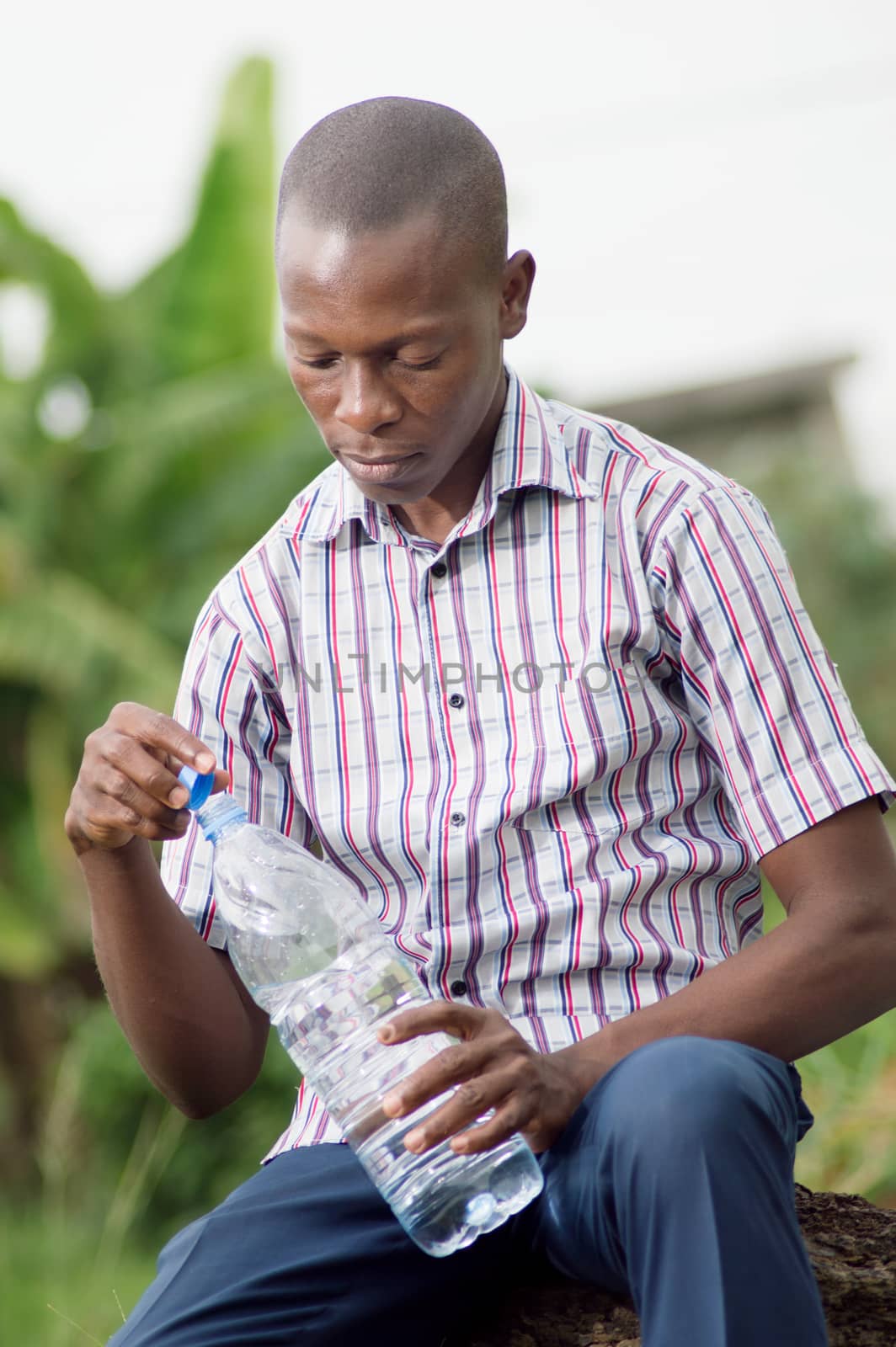 This young  man open the bottle of water to drink.