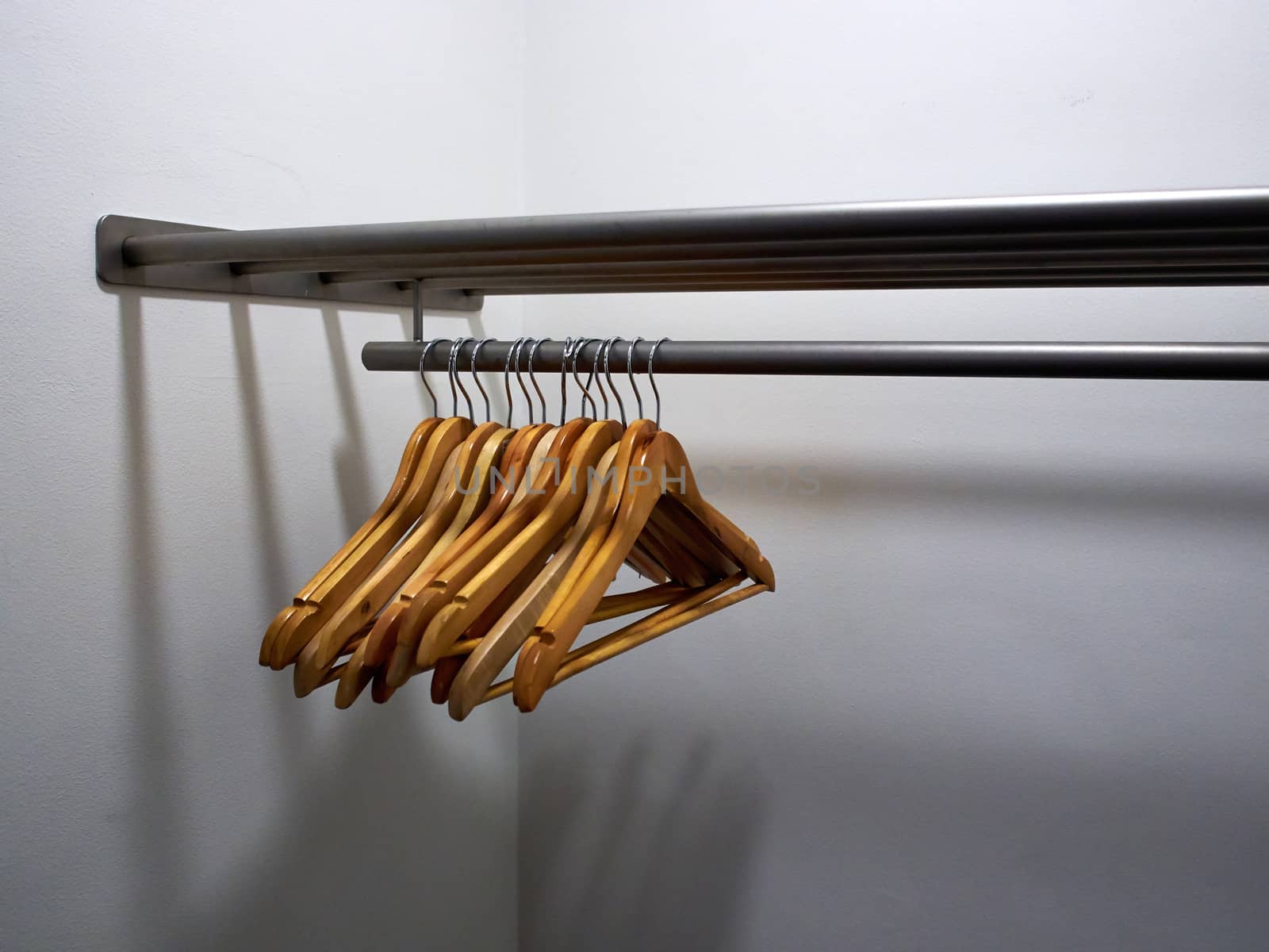 Wooden clothes hangers on a metal rack in a wardrobe dressing room