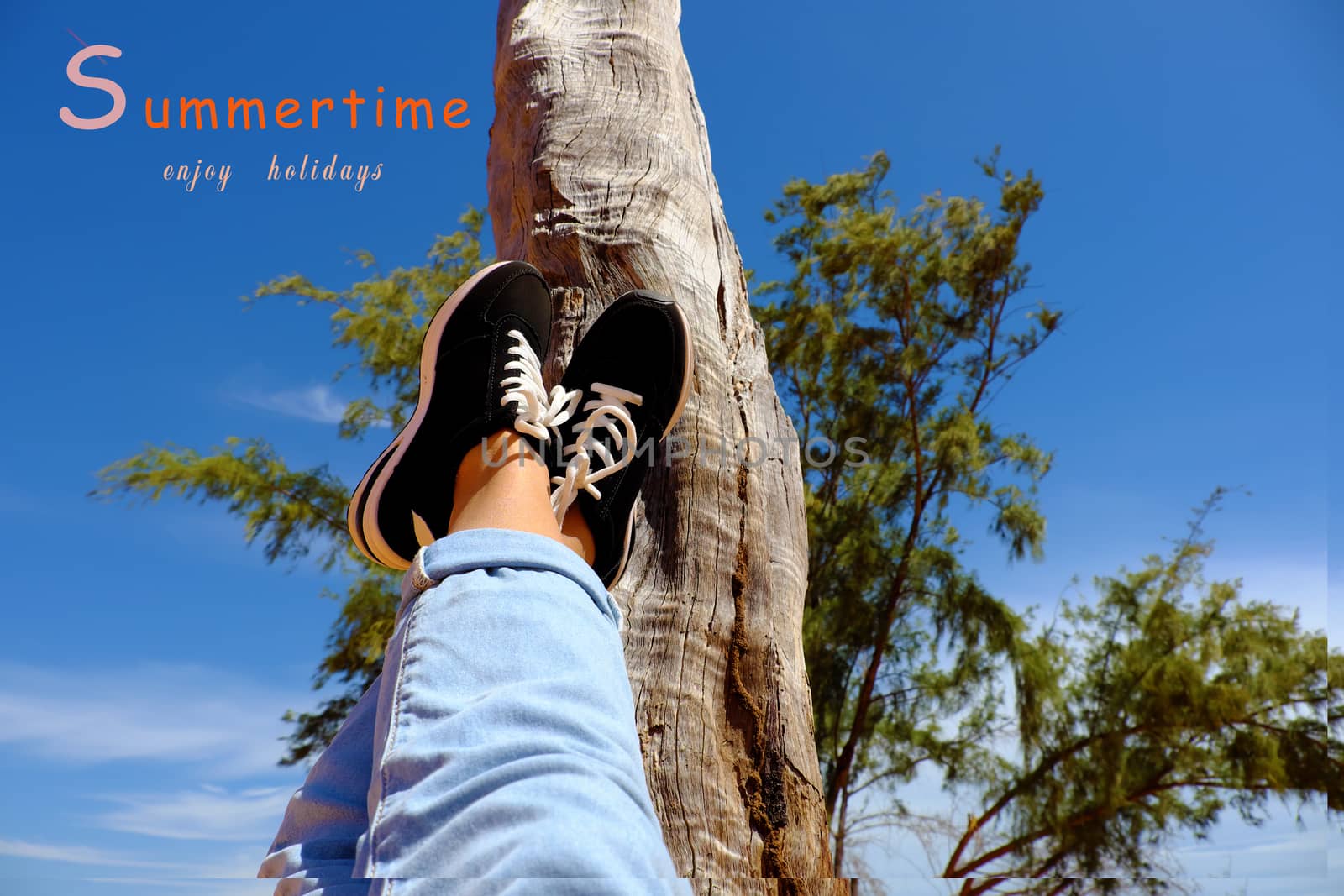 Girl travel alone and enjoy summertime by raise legs up to sky, people relax under tree to happy summer holiday