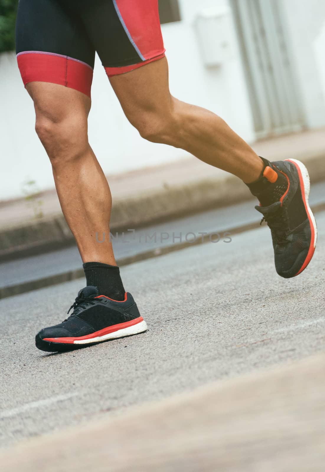 Male athlete running on the street.