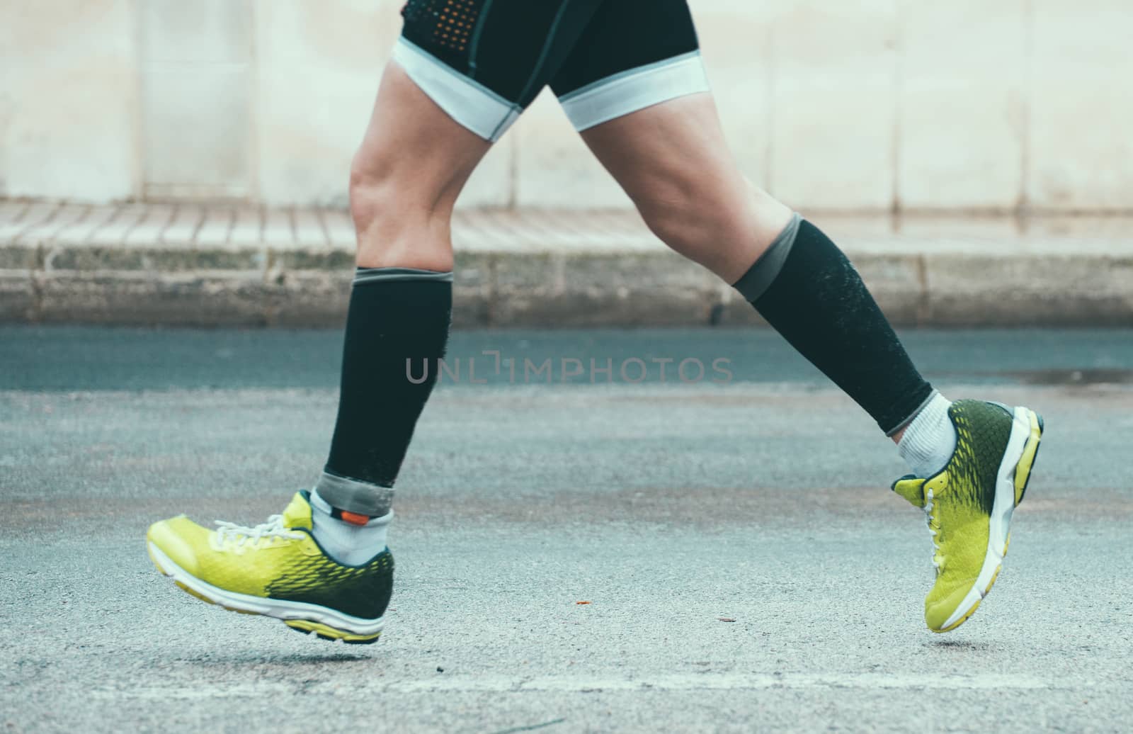 Male athlete running on the street.