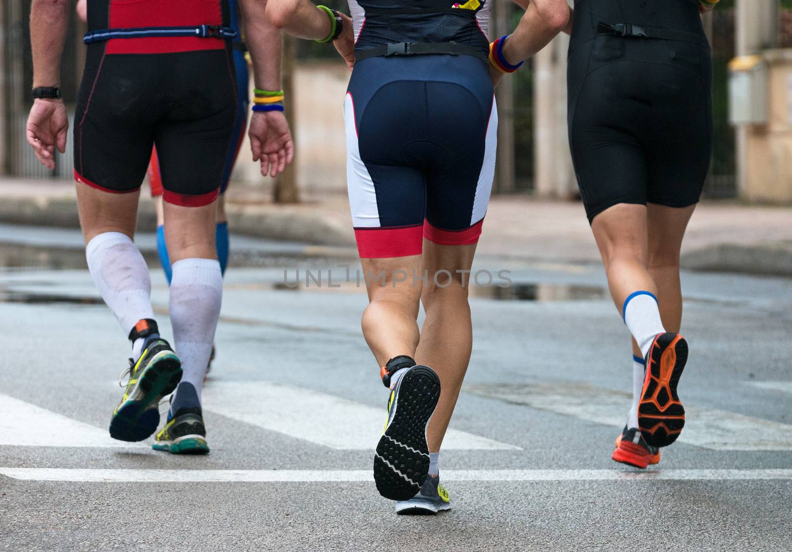 Group of marathon runners on the street. Back view. by dmitrimaruta