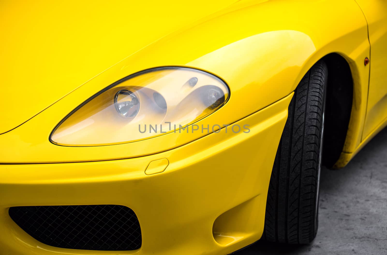 Close-up view of yellow sports car headlight.