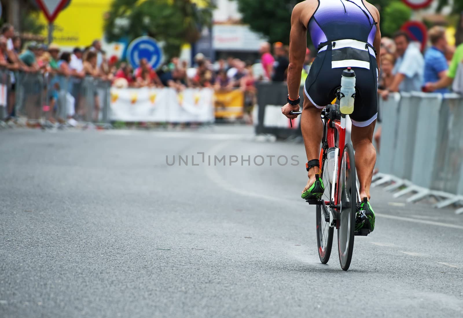 Unrecognizable professional cyclist during the bicycle competition. Back view. by dmitrimaruta