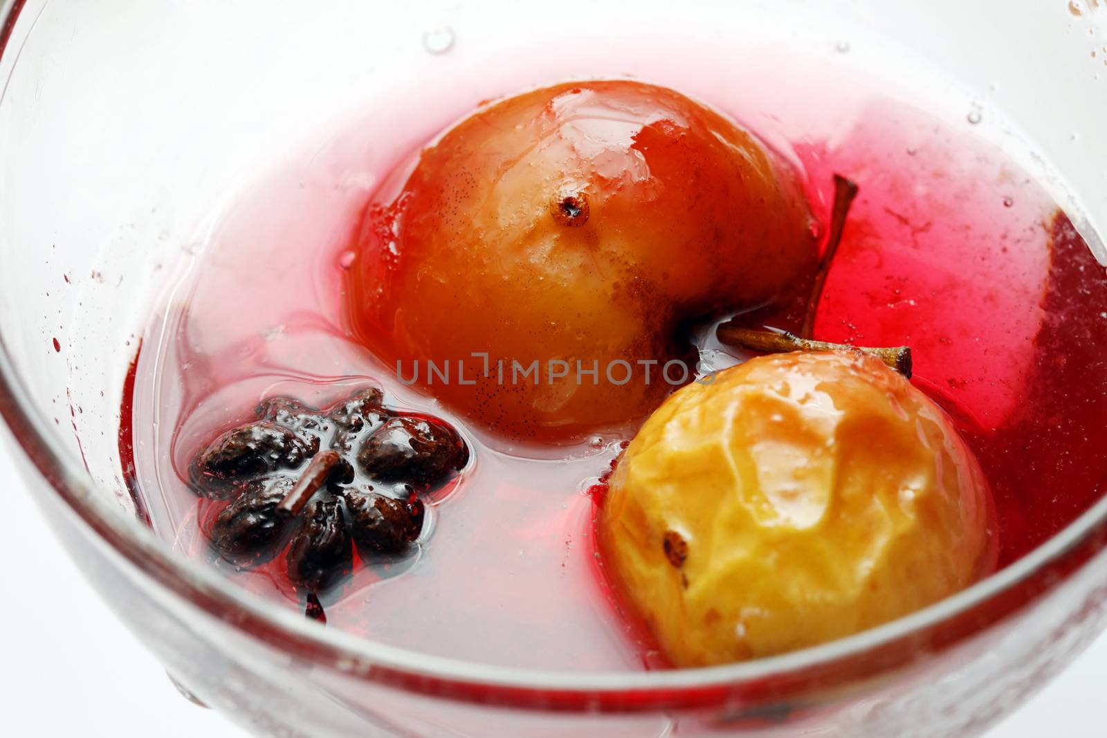 Red apple in rose syrup with anise over isolated white background