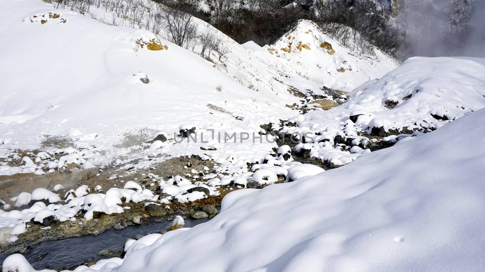 Closeup stone and stream in the mist Noboribetsu onsen snow winter national park in Jigokudani, Hokkaido, Japan