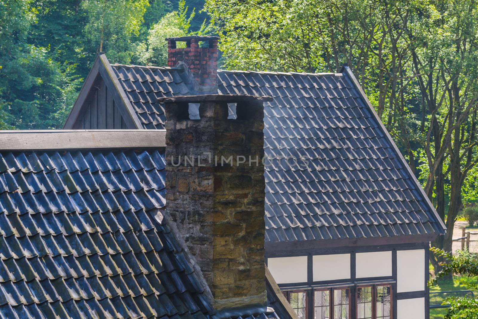 Smoking chimney on the roof of a house.