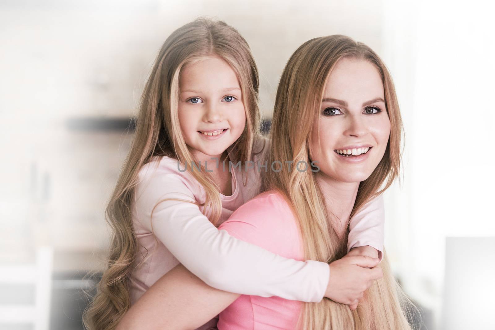 Mother and piggy back ride daughter at home