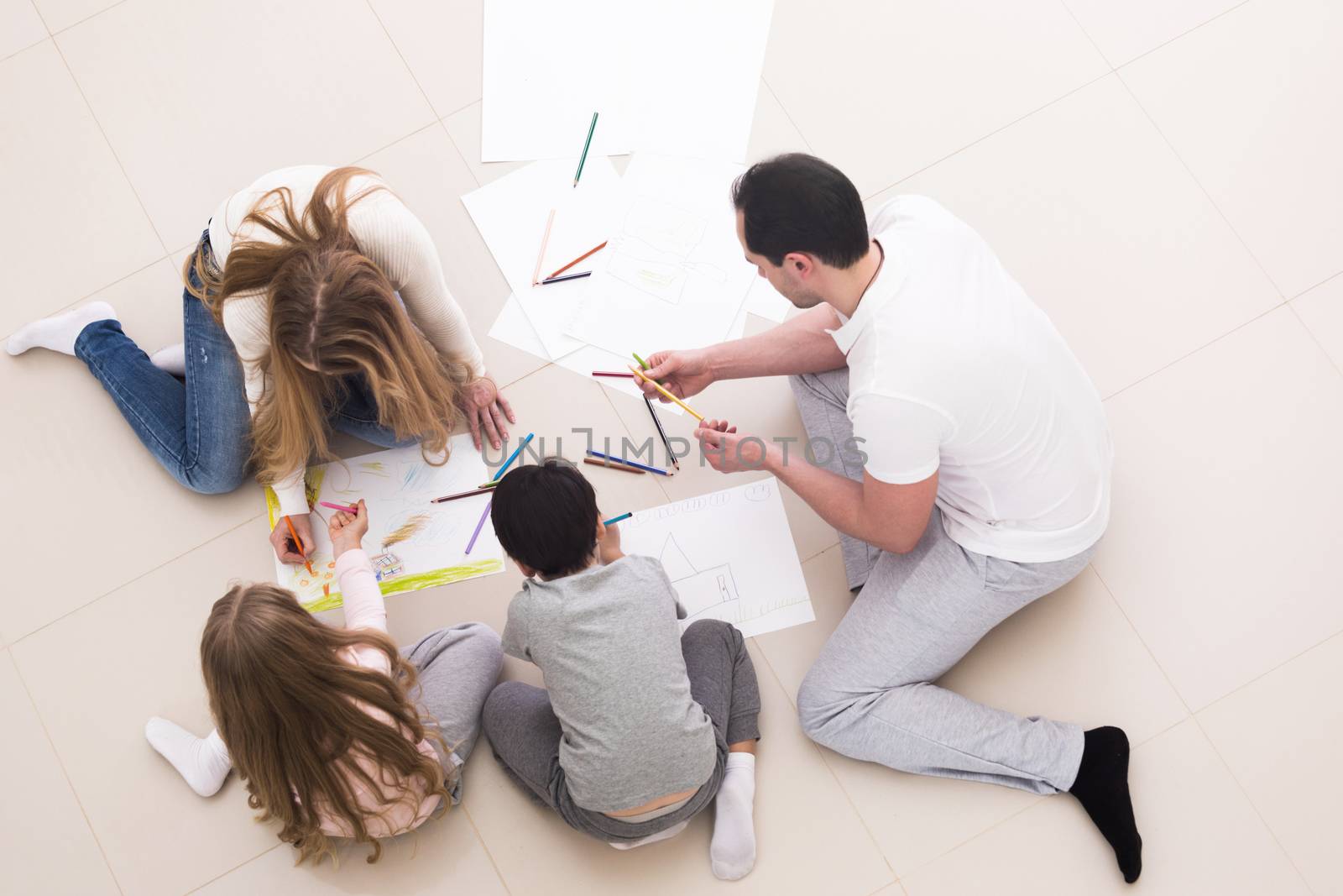 Happy family of four people drawing together at home