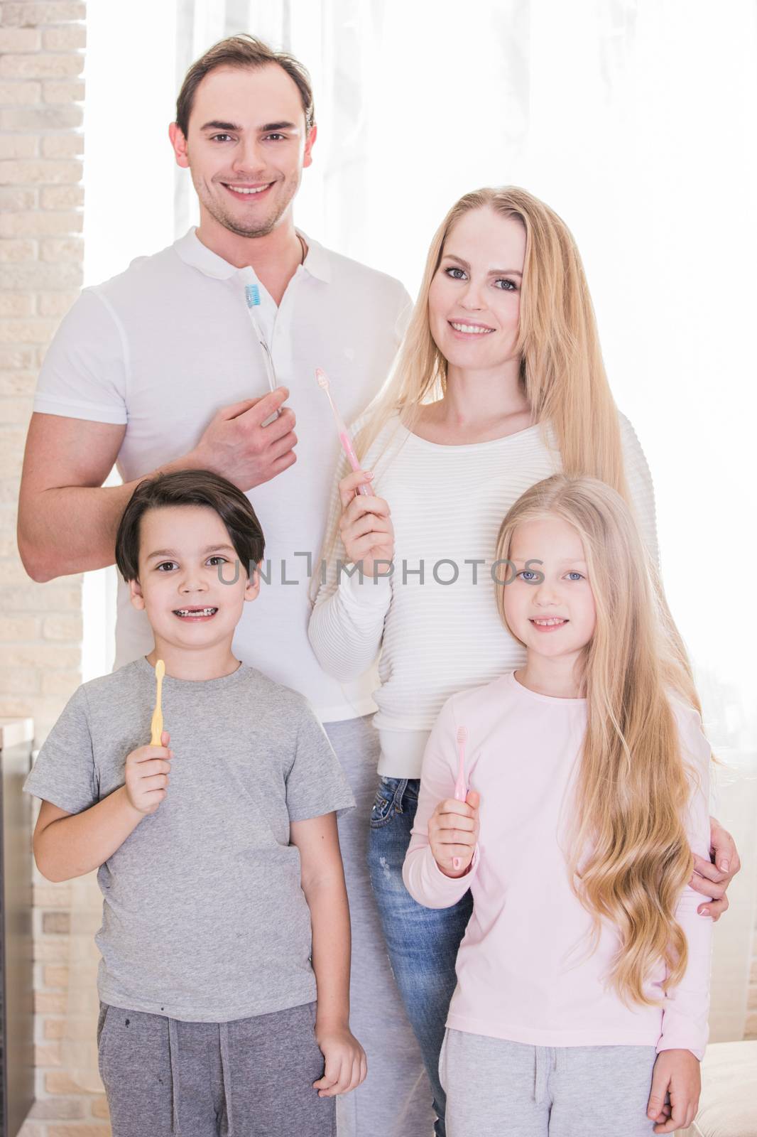 Happy family of four people with toothbrushes