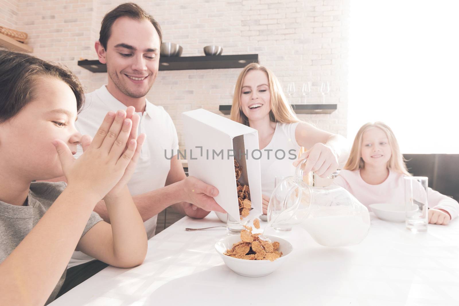 Family having breakfast with flakes and milk