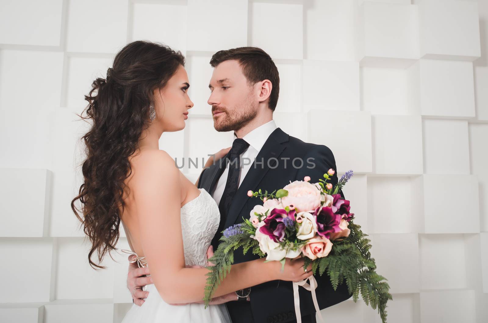 Just married young couple dancing, studio shot