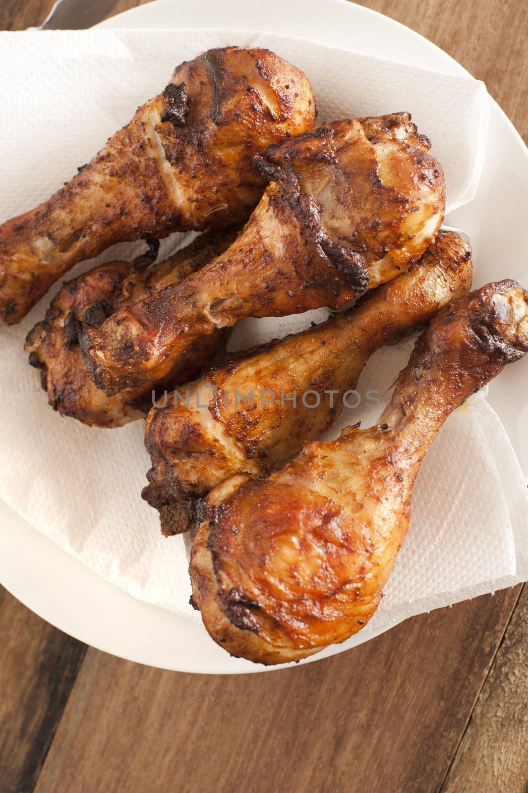 Close up on four roasted drumsticks by stockarch