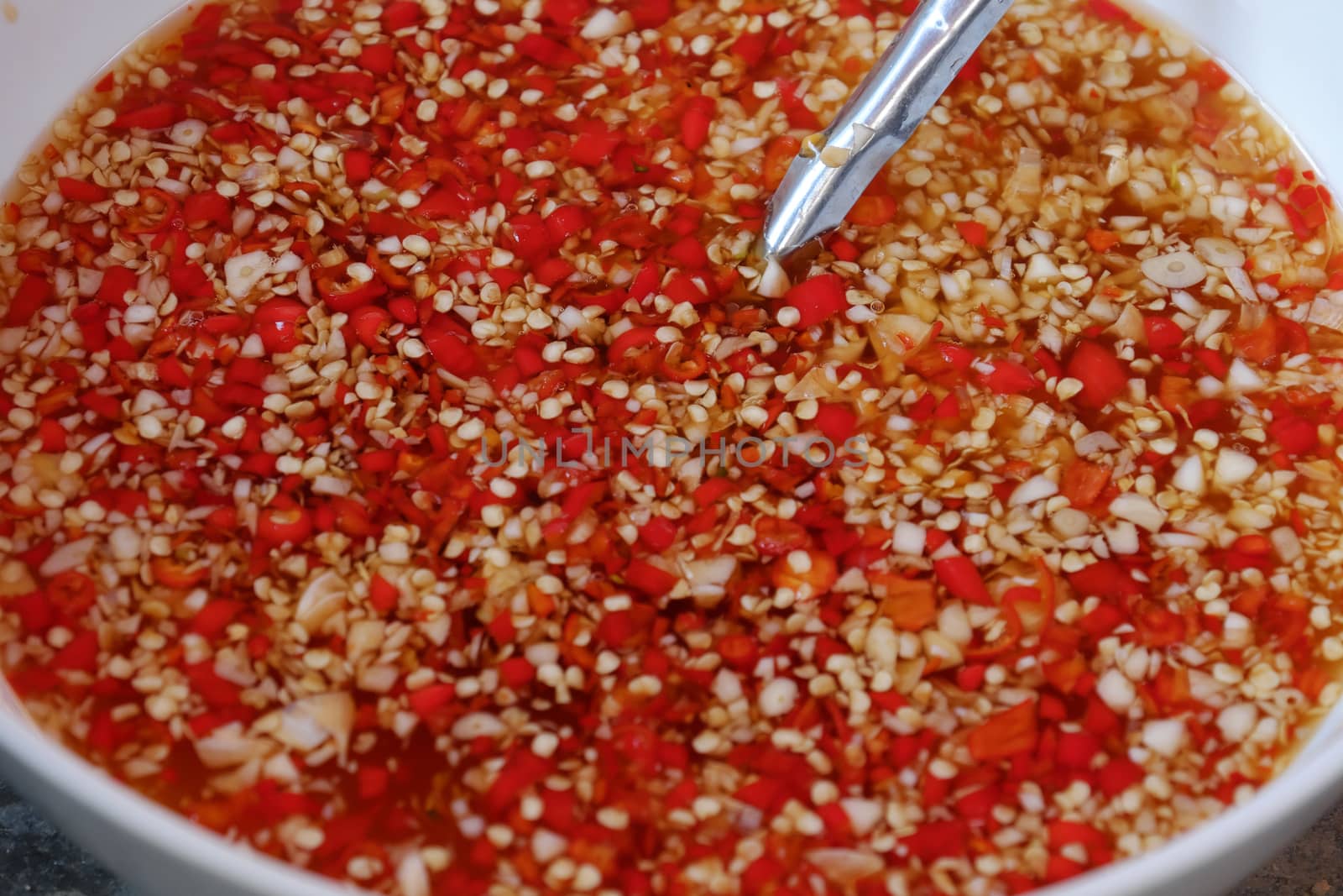 Vietnamese sauce for food, fish sauce with red hot pepper and choped garlic, amazing bowl of red