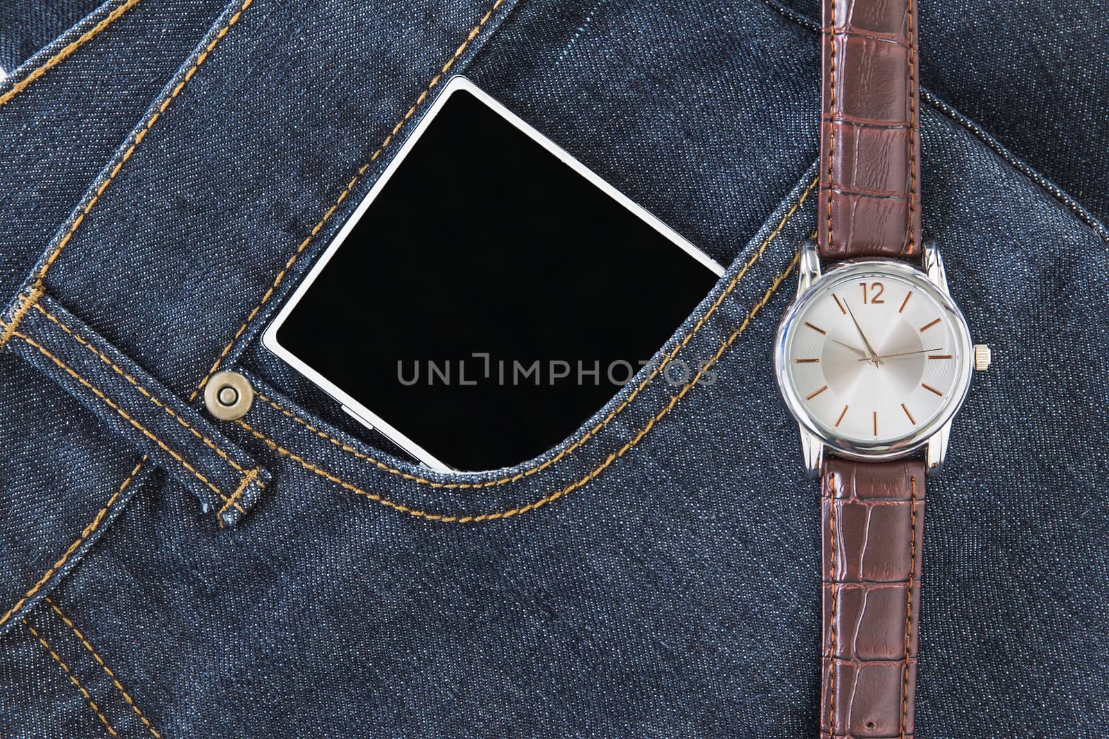 Wrist watch and smartphone on jeans by stoonn