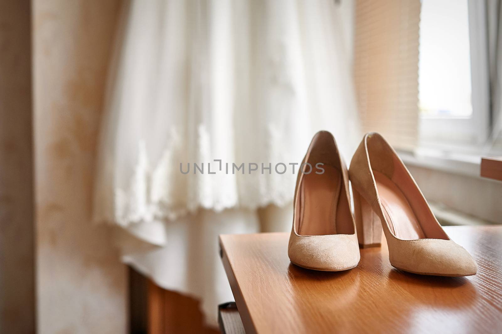 wedding shoes and bride in a bedroom.