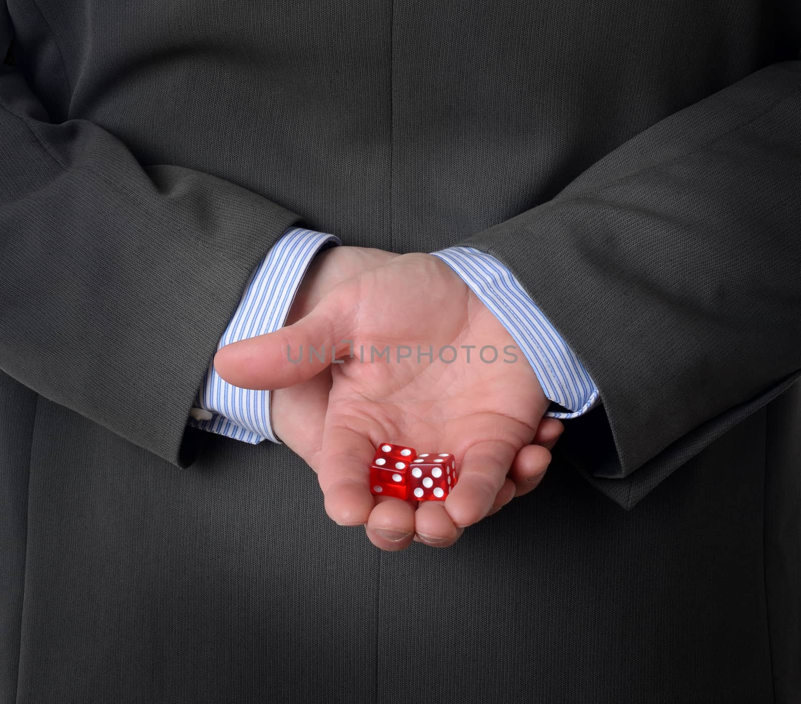 Man in suit with dice behind his back by hyrons