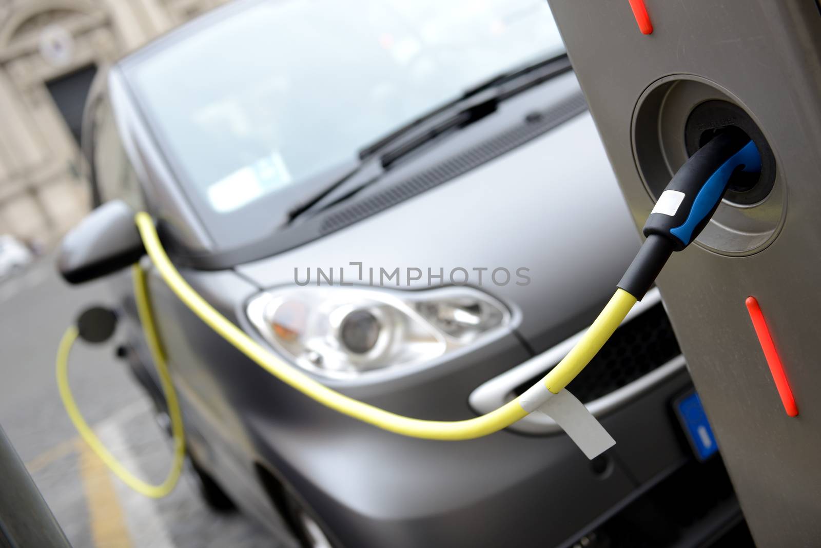 Power supply for electric car charging. Electric car charging station. Close up of the power supply plugged into an electric car being charged.