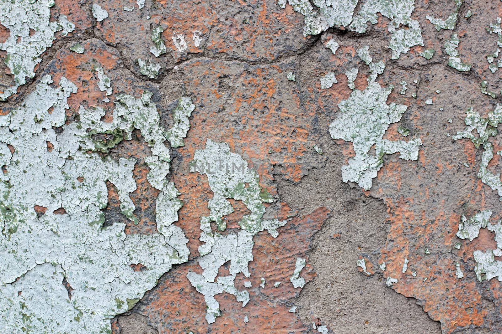 Tatter of a multi-colored old paint on a surface of a stone wall